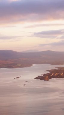 İrlanda kıyıları yakınlarında gün batımında manzaralı kıyı ve dağları keşfetmek.