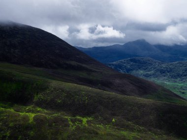 Coomloughra At Nalı 'nda bulutlu bir gün. İrlanda' nın Kerry ilçesinde yeşil dağlar ve bulutlu gökyüzü görülüyor..