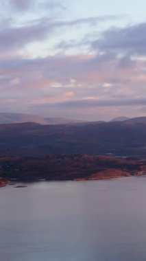 Güneş İrlanda kıyılarında batarken kıyı ve dağların güzel manzarasının tadını çıkarıyorlar..