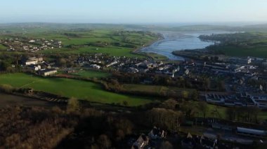 Güneşli bir sabahta İrlanda, Clonakilty 'ye yüksek bir bakış. Kasabayı yeşil tarlaların arasına yerleştir. Yakınlarda nehir haliçleri olsun. Özellikler evler, binalar ve manzaralı manzaralar.