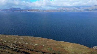 Uçurumlardan çarpıcı bir manzara parçalı bulutlu bir günde geniş Atlantik Okyanusu 'nu ve uzak İrlanda dağlarını gösteriyor..