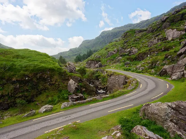 İrlanda 'nın Kerry ilçesindeki engebeli Dunloe Geçidi' nden geçen manzaralı viraj yolu.