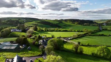 West Cork, İrlanda, 3 Mayıs 2025. Bir hava perspektifi İrlanda 'nın West Cork kentinin çarpıcı manzarasını gözler önüne seriyor. Parçalı bulutlu gökyüzünün altında yuvarlanan yeşil otlaklar ve dağınık çiftlik evleri.