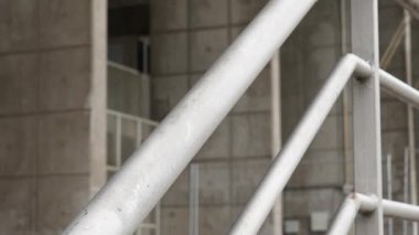 Beton binanın arka planında galvanize çelik sokak korkuluğu yakın plan