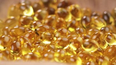 Omega 3 saydam altın kapsüller. Beslenme takviyeleri. Polyunurated yağ asitleri sarı haplar. Makro. Döndürme