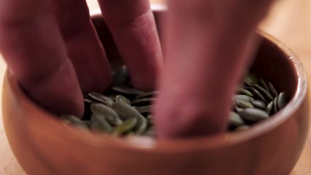 Bir Kabuklu Yeşil Kabak Tohumlarını Kırsal Bir Ahşap Kaseden Alır — Stok video
