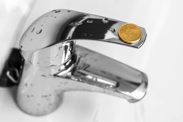 浴室水龙头上的20欧元硬币 节约用水的概念观念 家庭财政预算储蓄概念 — 图库照片