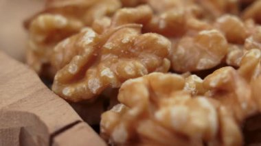 Kırsal bir kasede soyulmuş ceviz çekirdeği. Kuru fındık çekirdekleri. Döndürme. Makro