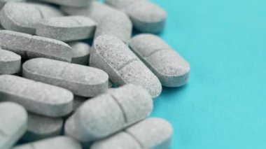 Renkli mavi arka planda Tryptophan yatıştırıcı haplar. Depresyon ve uykusuzluk için tıbbi tedavi. Doğal eczacılık antidepresanları. Döndürme