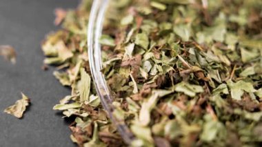 Kurutulmuş süt devedikeni yaprakları. Alternatif bitkisel ilaç kuru malzemesi yavaş çekimde düşüyor. Makro çekim