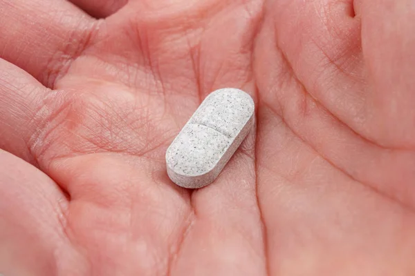 stock image Sedative pills with tryptophan in hand close-up. Remedy for depression and insomnia. Natural pharmaceutical antidepressant