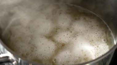 Lokantanın mutfağında köpüklü çorba ile kaynayan bir tencere.