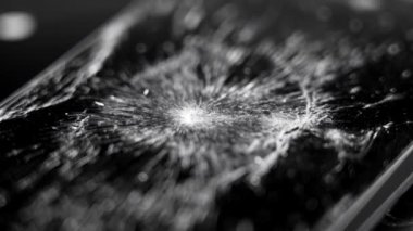 Shattered glass touch screen mobile phone. Broken smartphone black texture. Macro shot. Rotation