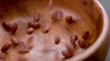 Chocolate cereal puffed rice flakes. Falling crispy popped breakfast grains into a wooden bowl. Macro. Rotation