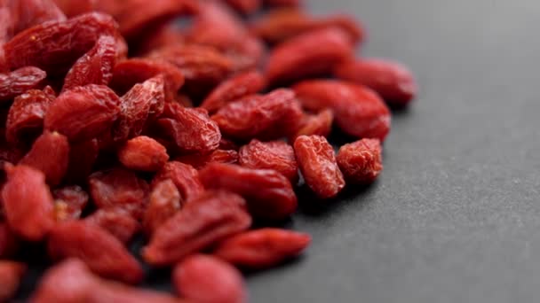 Red Organic Dried Goji Berries Black Surface Macro Rotation — Vídeo de Stock