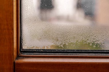 Dampness in the apartment. Wet PVC window with drops of water condensate