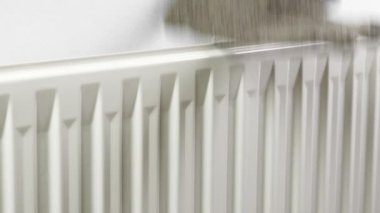 Drying wet winter woolen warm gloves on a hot heater in the room