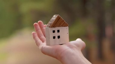 Vahşi orman doğasının çevreci yeşil arka planına sahip ahşap ev modeli. Eko konut kavramı