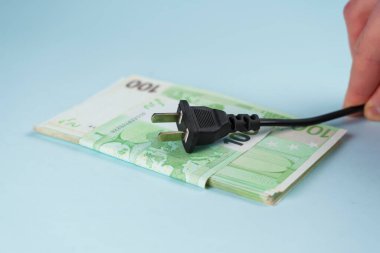 Avro para kaynağının elektrik prizi elinde. Pahalı elektrik tedarik kavramı