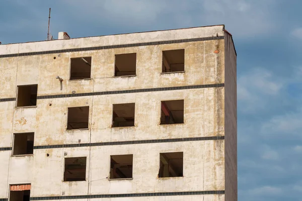 Çökmüş pencereleri olan harap bir ev.