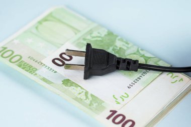 Mavi arka planda Avrupa 'dan gelen bir deste para üzerinde elektrikli cihaz eklentisi