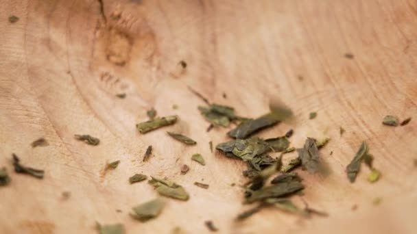 乾燥した日本の煎茶緑の茶葉はゆっくりとした動きで木の素朴なボウルに落ちる閉じる — ストック動画