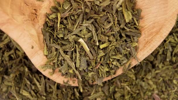 乾燥日本の煎茶木製の素朴なボウルに緑の茶葉を閉じます — ストック動画