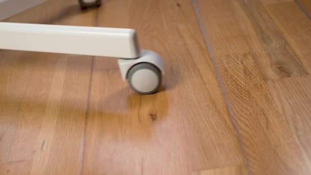 在房间的层压板地板上滚动一个塑料橡胶轮 — 图库视频影像
