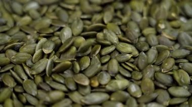 Yeşil organik balkabağı çekirdekleri yavaş çekimde düşüyor.