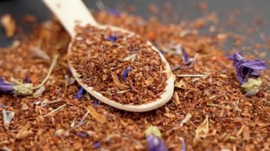 Rooibos çiçekli bitki çayı ahşap bir bambu kaşığa saçılmış. Yaklaş. Döndürme. Rahatlayın.