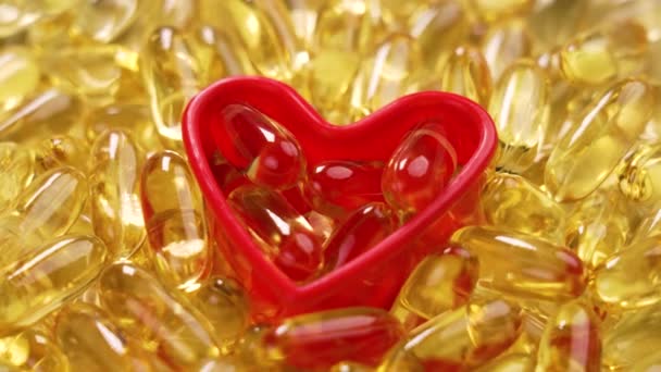 Yellow Omega Capsules Red Heart Shape Scattered Natural Sea Fish — Stock Video