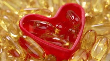 Plastik bir kalp şeklindeki Omega 3 kapsülü takviyesi