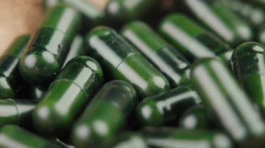 Bitki tozu doğal destek kapsülleri. Alternatif ilaç bitkisel haplar. Makro. Döndürme