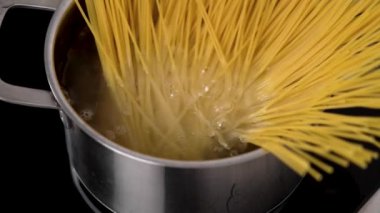 Tencerede kaynatılmış su, ocakta İtalyan spagettisi pişiyor.