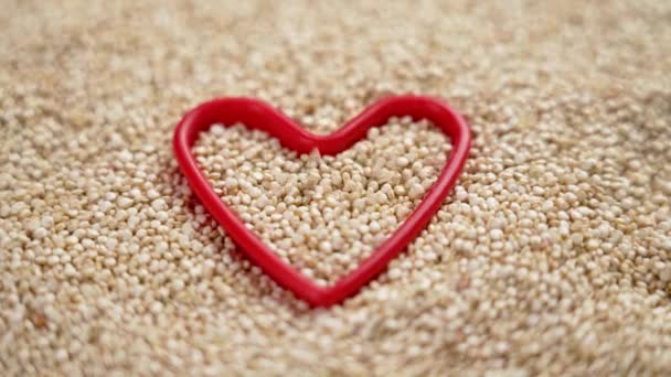 Fehér Organikus Quinoa Elefántcsont Magok Esik Egy Teljes Piros Szív — Stock videók