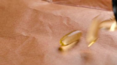 Omega yağ asitleri ile sağlıklı doğa takviyeleri. Plastik şişeden düşen sarı kapsüller.