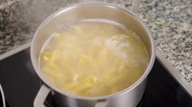 Çelik tavada glütensiz makarna pişiriyorum.