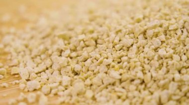 Biyo-çözünür kedi kumundan yapılmış mısır kumu yakından geliyor. Döndürme. Stüdyo çekimi. Yavaş çekim