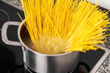 Fırında kaynar su dolu bir tencerede spagetti pişiriyorum.