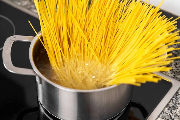 ストーブの上で沸騰したお湯の鍋でスパゲティを調理 — ストック写真
