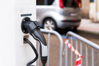 Şehirdeki yeşil yenilenebilir enerji araba şarj istasyonunun elektrik prizi.
