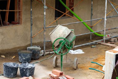 İnşaat alanında inşaat iskelesi olan mobil elektrikli beton karıştırıcı