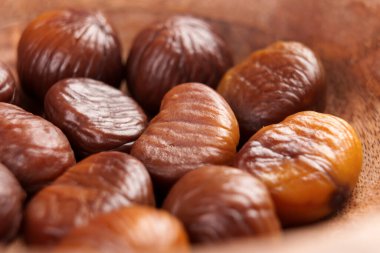 Ahşap bir kasede kavrulmuş kabuklu lezzetli kestane fıstığı. Makro