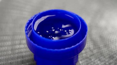 Plastik şişe kapağında mavi çamaşır deterjanı var. Baloncuk hareketleri. Temizlik kavramı