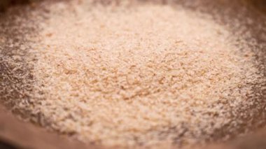 Su dolu ahşap bir kasede Psyllium tohumu kabukları yığını. Sağlıklı glütensiz diyet için süper yiyecek içme takviyesi