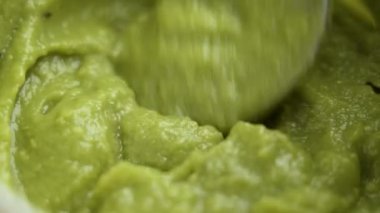 Yeşil püre Meksika avokado sosu (guacamole) kaşıkla hazırlanıyor.