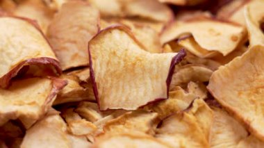 Bir el, tek bir kurutulmuş elma parçacığını alır. Yığından yaklaş.