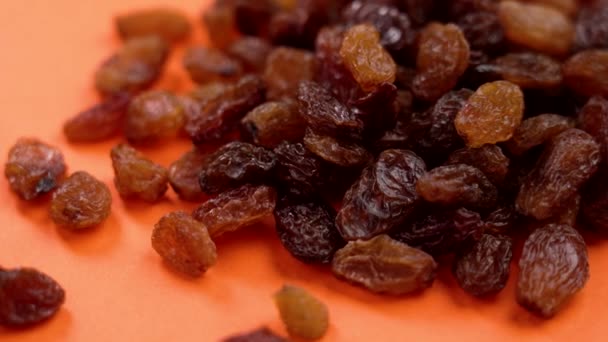 Braune Rosinen Auf Orangefarbenem Hintergrund Getrocknete Traubenfrüchte Natürliche Gesunde Zutaten — Stockvideo