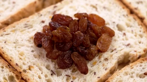 甜葡萄干或干葡萄放在新鲜的切碎面包上 — 图库视频影像