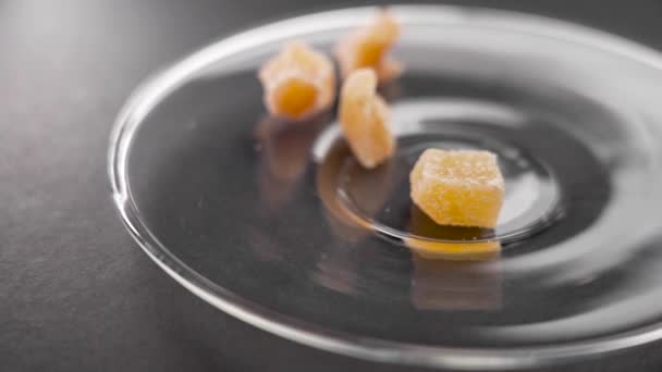 结晶成糖的姜片以慢动作掉在玻璃碟上 甜食健康食品 — 图库视频影像